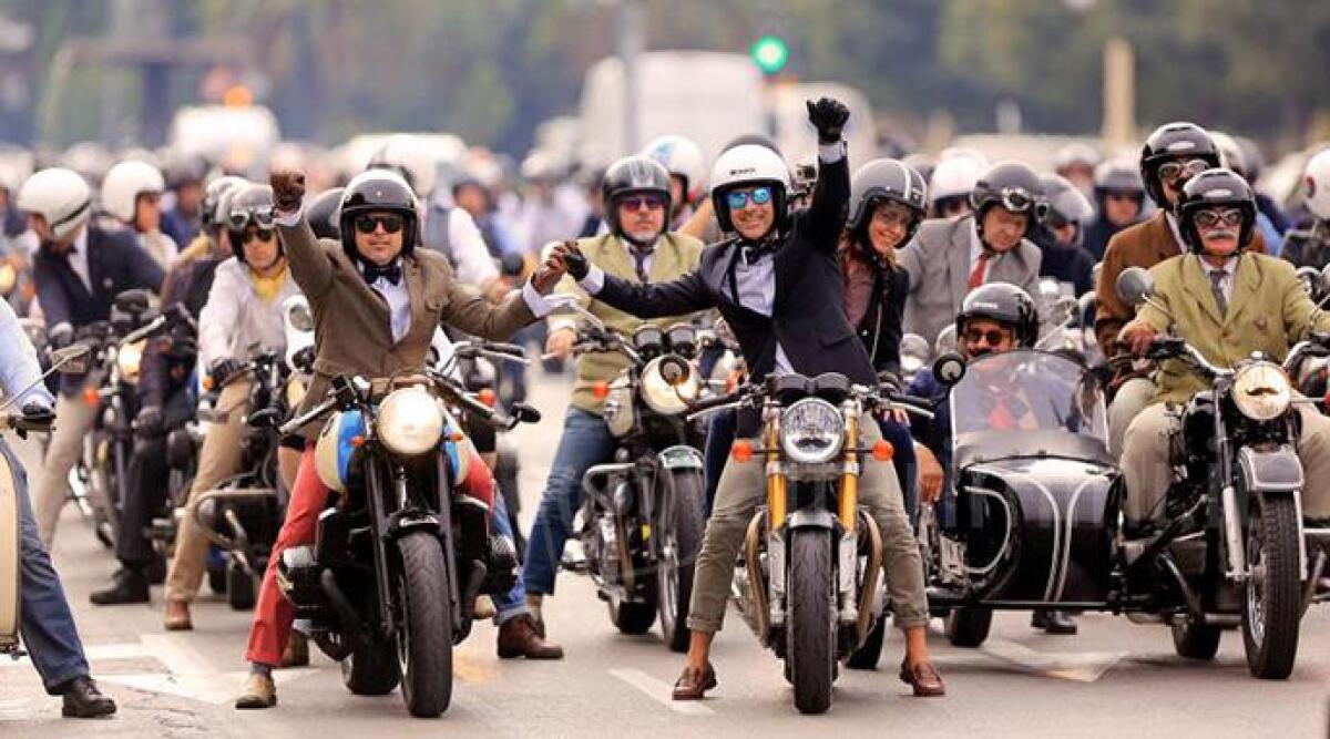 Parata solidale di moto &lsquo;classiche&rsquo; con motociclisti in abiti eleganti - 