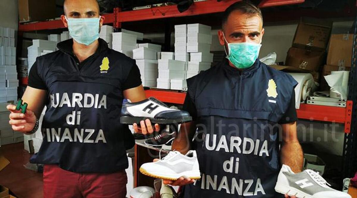 FOTO Blitz nel negozio e nel laboratorio di scarpe false: sequestrate 500 paia di Hogan contraffatte -