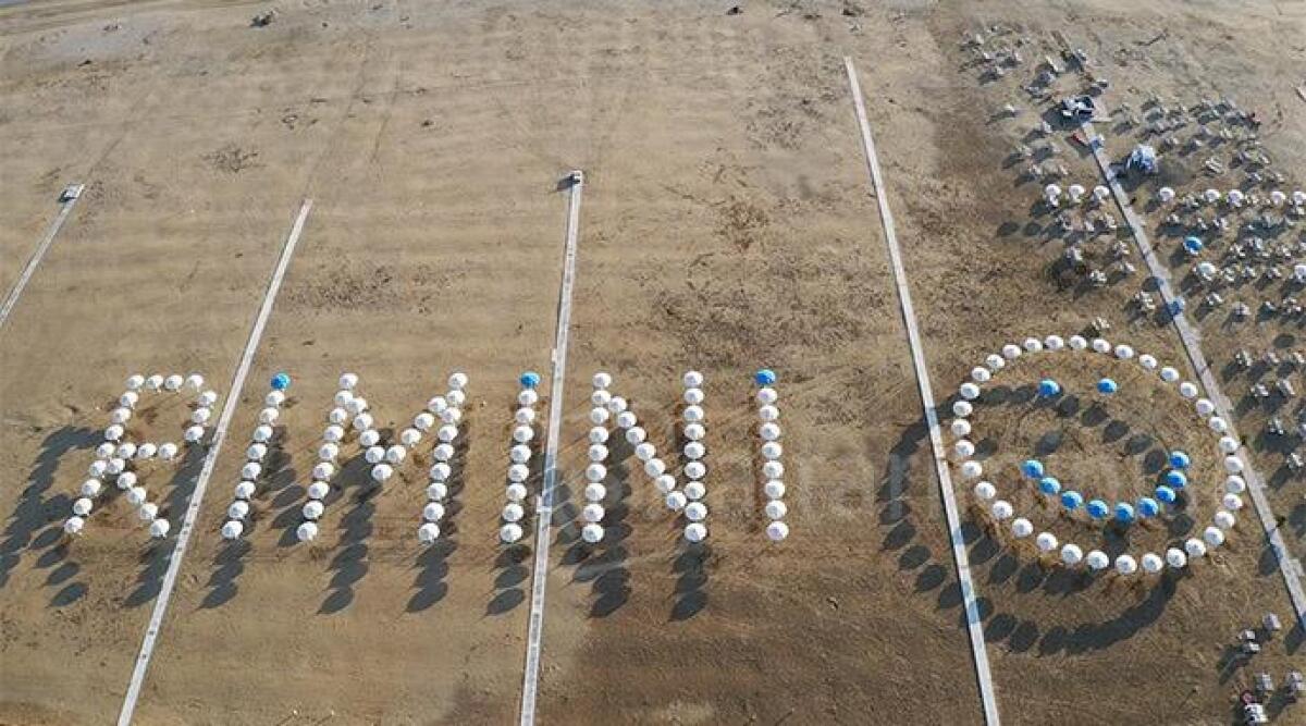 FOTO La scritta Rimini sulla spiaggia con gli ombrelloni dà il benvenuto al Giro d'Italia -