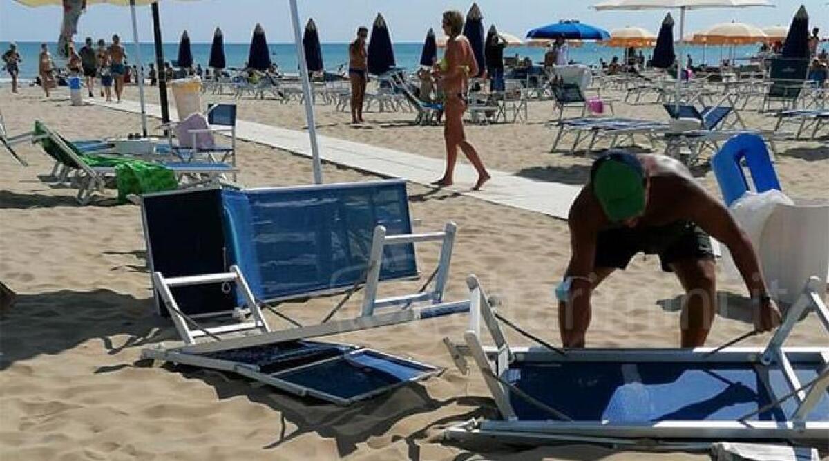 Vortice in spiaggia a Rimini: volano lettini, ombrellone squarciato -