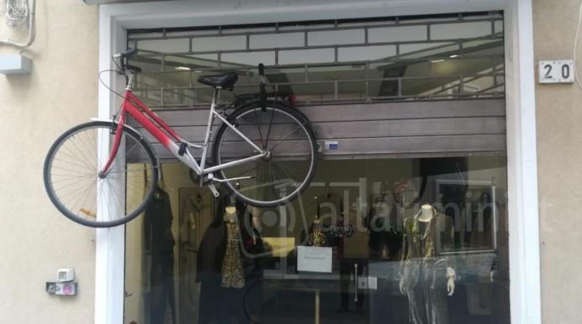 Legata con lucchetto alla serranda del suo negozio: la bici resta a mezz'aria - 