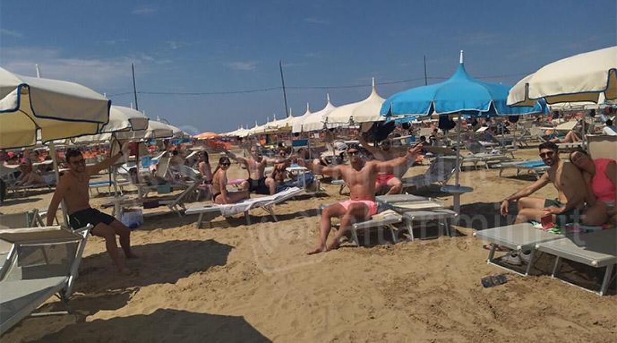 A Rimini antipasto d'estate: primi bagni e gente in spiaggia - Bagnanti al bagno 26 di Rimini. In gallery il Bagnino d'Italia Gabriele Pagliarani