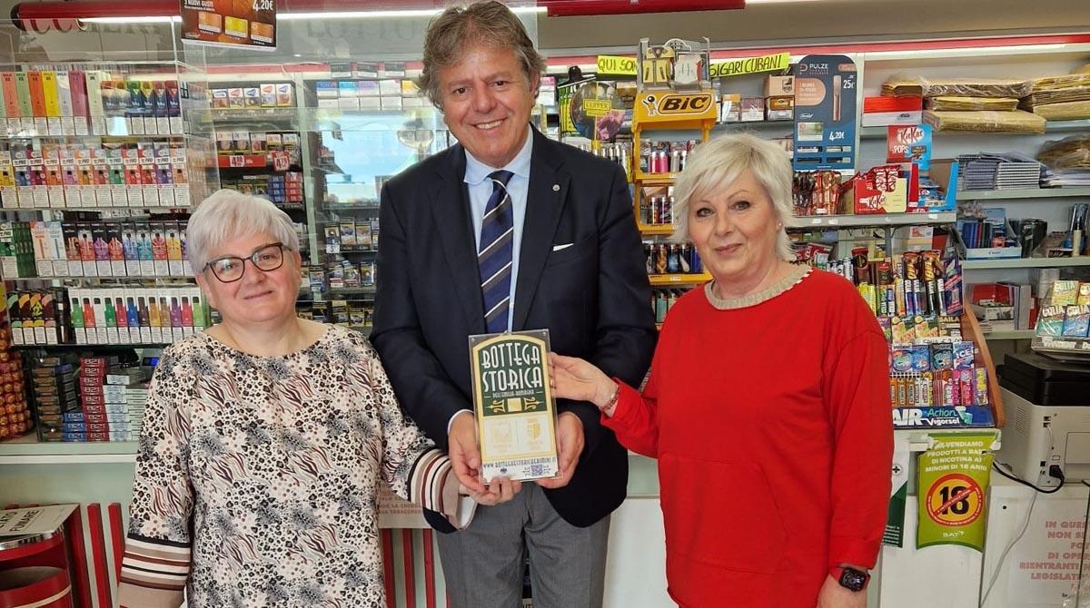 Tabaccheria Biagini, quasi 100 anni di storia e quattro generazioni di donne alla guida - Le sorelle Cevoli ricevono la targa di bottega storica da Gianni Indino