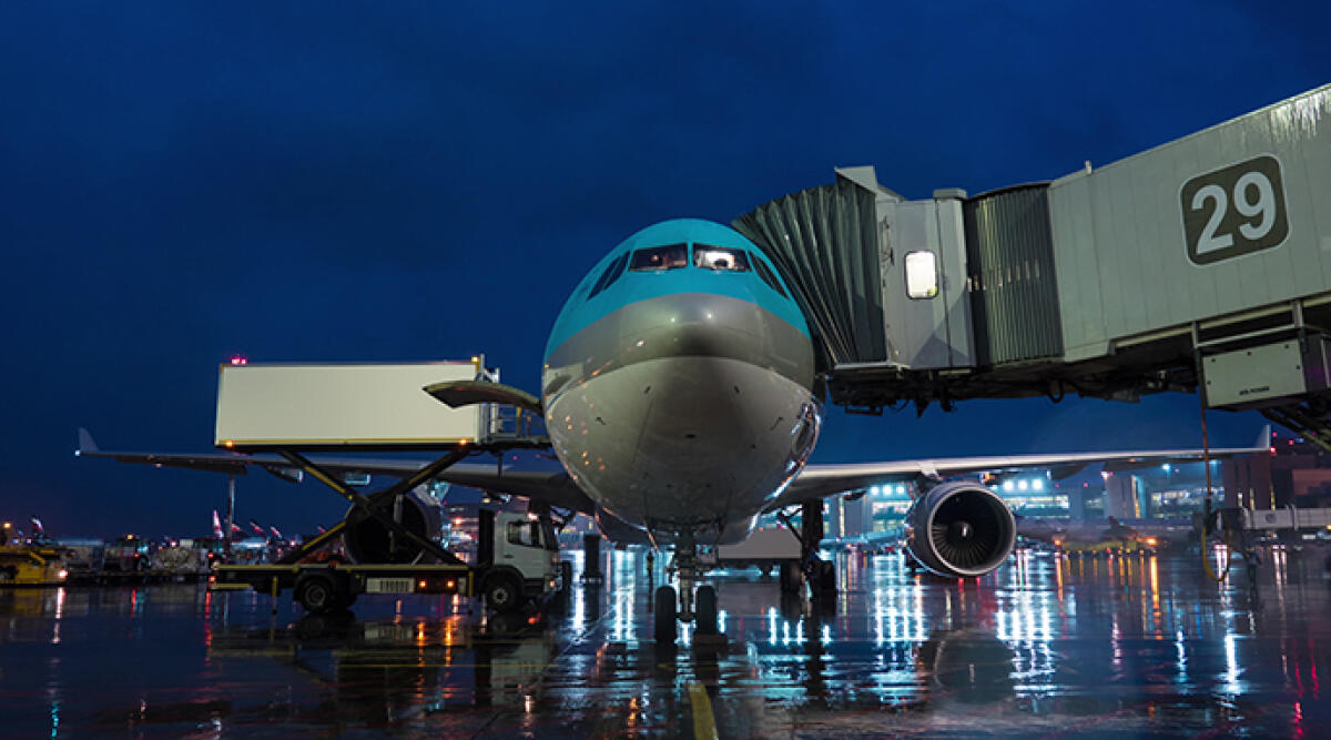 Aeroporto di Bologna: voli notturni garantiti, ma con modifiche per ridurre i sorvoli sulla città - shot of deboarding and unloading arrived airplane at night. View to the cockpit, airbridge and cargo lifting machine. File is ready for commercial use, logos and trademarks are removed
