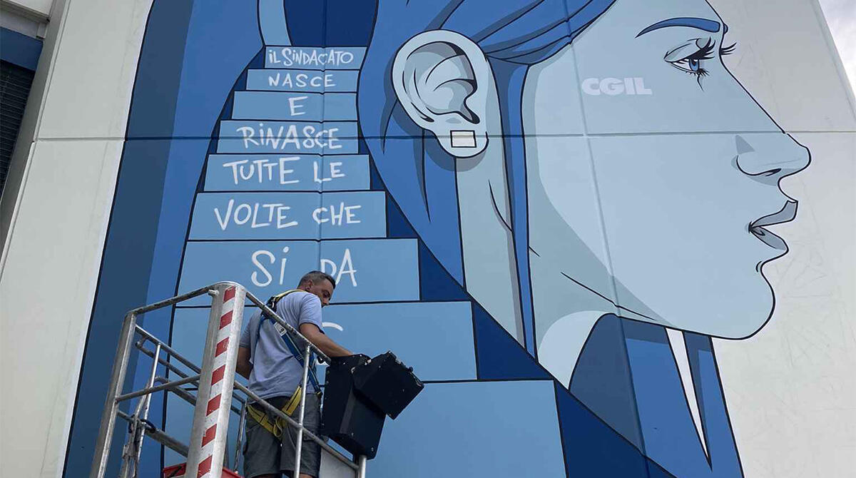 JodyPinge celebra i 120 anni della Camera del Lavoro di Rimini con un murale unico - JodyPinge all'opera sul murale