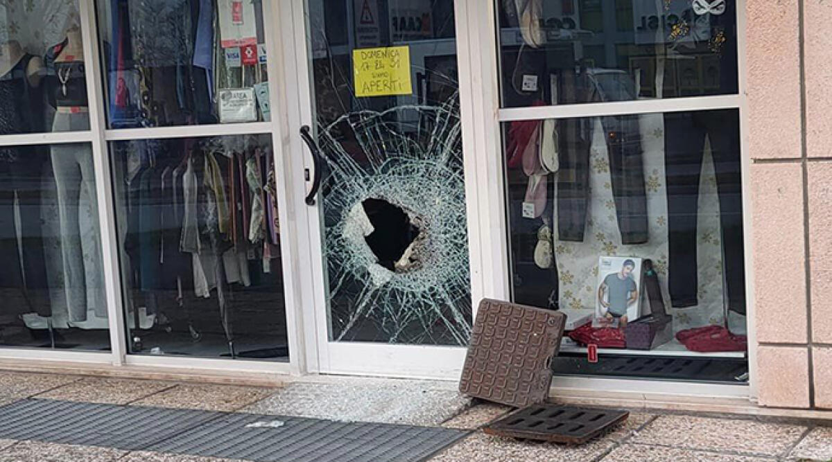 Serie di furti e 'spaccate' con l'utilizzo di tombino colpiscono attività commerciali a Rimini - La porta vetrata distrutta del negozio Follia Intimo