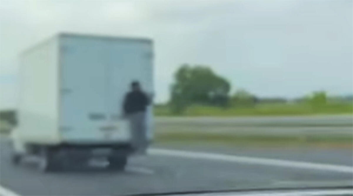 Misterioso passeggero "attaccato" sul retro di un furgone in autostrada - Un fermo immagine del video