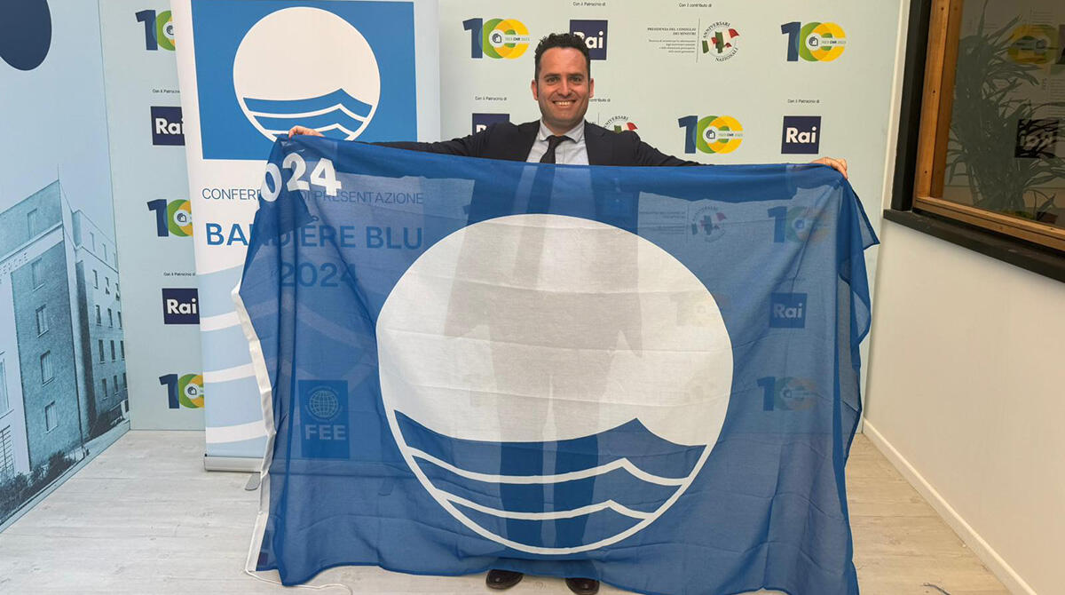 Riccione si prepara a sventolare la bandiera blu: cerimonia in piazzale Roma - L' Assessore Christian Andruccioli con la Bandiera Blu