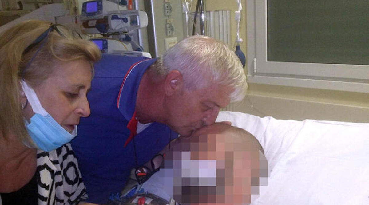 Caso Tucci, nuove testimonianze: pugni anche a terra - Claudio Tucci, padre di Giuseppe mentre bacia il figlio, nel reparto di Rianimazione dell'ospedale Infermi di Rimini, in una foto pubblicata sul suo profilo Facebook